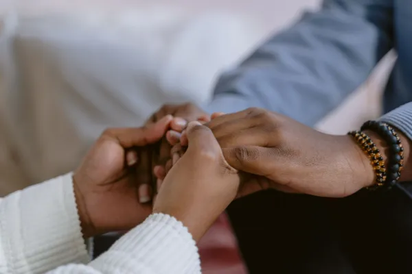 Two people holding hands in a moment of comfort and support